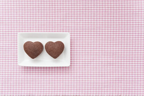 Schokoladenvalentinekuchen auf rosa Tuch (Herzform)) — Stockfoto