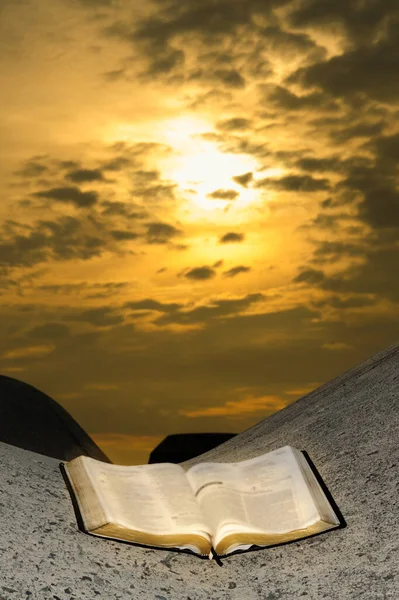 在有惊人日出的防波堤上打开圣经 — 图库照片