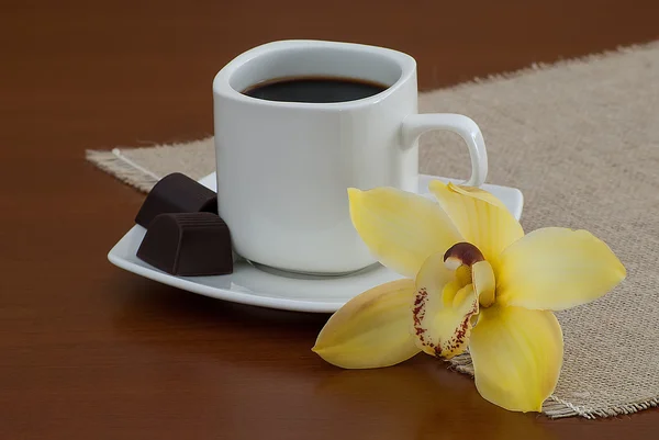 Xícara de café preto com chocolates — Fotografia de Stock