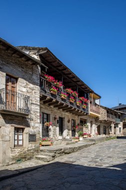 Puebla de Sanabria, Zamora, İspanya; Temmuz 2021: Puebla de Sanabria, İspanya, Castilla y Leon 'da taş binaları ve çiçekli eski köy