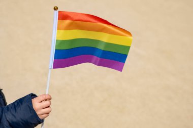 Eşcinsel gurur sembolü gökkuşağı bayrağını tutan küçük bir kızın eli