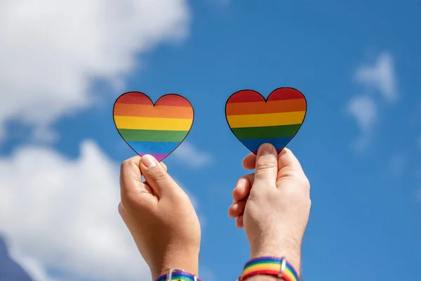 Duas Mãos Segurando Corações Com Bandeira Arco Íris Lgbt Céu Imagem De Stock