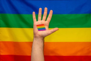 Avucunda gökkuşağı bayrağı dövmesi olan eşcinsel bir çocuk. Cinsel özgürlük ve hoşgörünün sembolü.