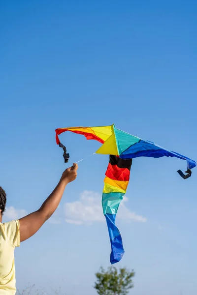 African American woman flying a colorful kite