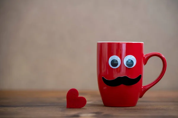 red mug with mustache and funny eyes looking up with a red  heart