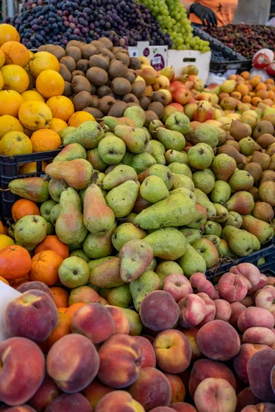 Variety of fresh fruit in crates at an open-air farmers\' market