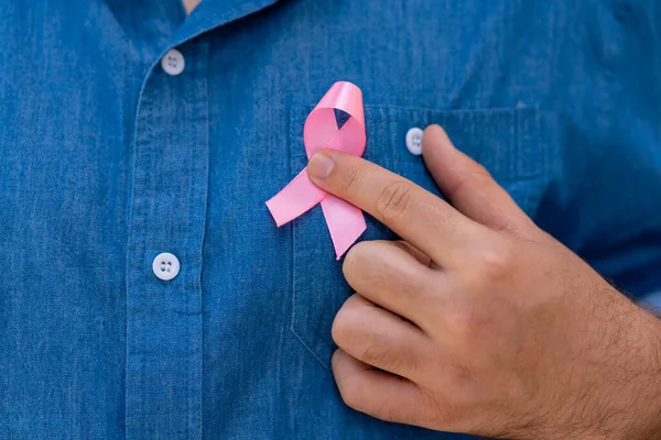 男子举着浅粉丝带支持病人和病人 乳腺癌意识概念 — 图库照片