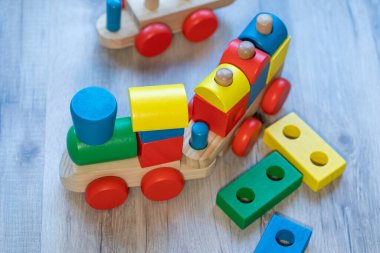 Gri ahşap zeminde renkli blokları olan tahta oyuncak tren.