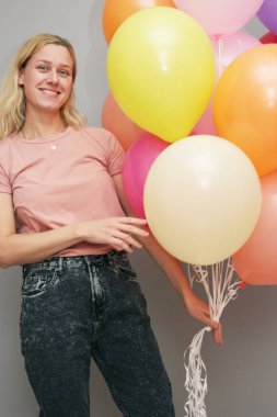 Çok renkli balonları olan sarışın bir kız.