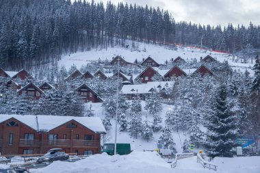 Kışın dağlarda ahşap evler, kayak merkezleri