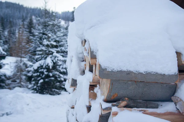 Brennholz Schnee Vor Der Kulisse Eines Winterwaldes — Stockfoto