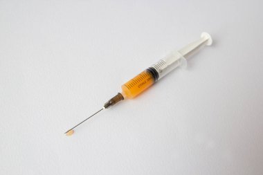 Portakal suyuyla dolu bir masada iğneyle bir şırınga yatıyor..