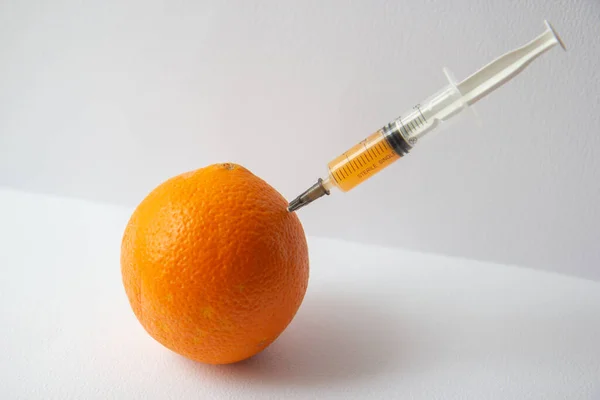 Une Orange Avec Une Seringue Coincée Dedans — Photo