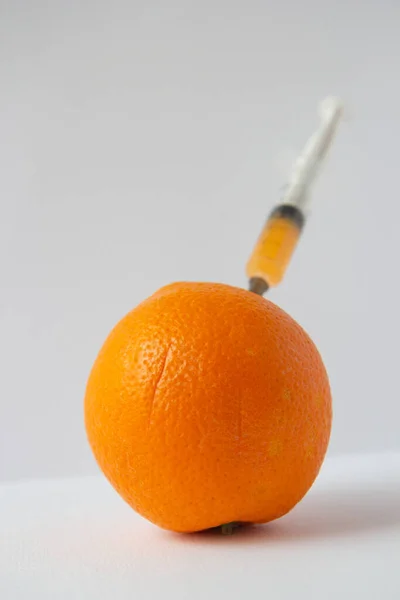Eine Orange Mit Einer Spritze Darin — Stockfoto