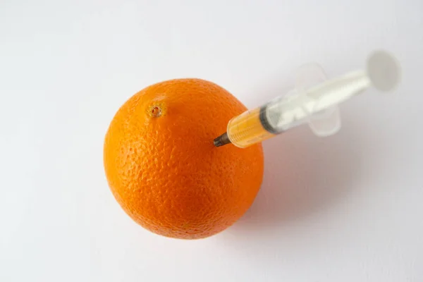 Eine Orange Mit Einer Spritze Darin — Stockfoto