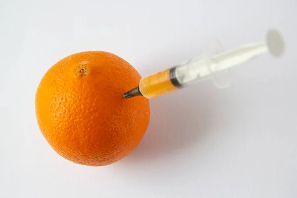 Eine Orange Mit Einer Spritze Darin — Stockfoto