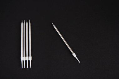 Siyah arka planda uzun gümüş mumlar