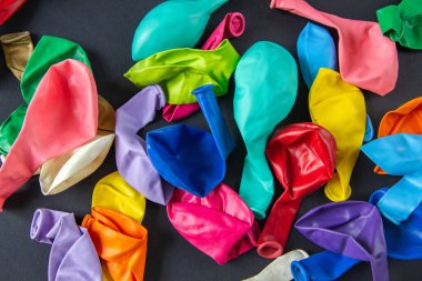 Siyah arka planda renkli lateks balonlar.