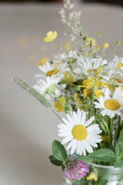 Kavanozda bir buket çiçek, masada, papatya çayı.