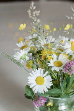 Kavanozda bir buket çiçek, masada, papatya çayı.