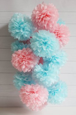 Beyaz arka planda ev için pembe ve mavi kağıt ponponlar.