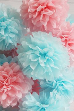 Beyaz arka planda ev için pembe ve mavi kağıt ponponlar.