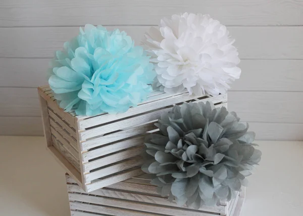 Multi-colored paper pom-poms on a white background, paper flowers, holiday decor