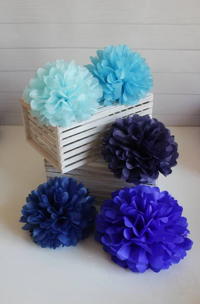 Multi-colored paper pom-poms on a white background, paper flowers, holiday decor