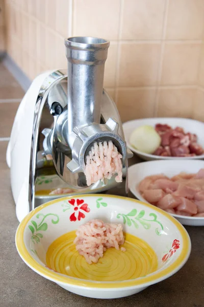 meat grinder grinds chicken meat into minced meat