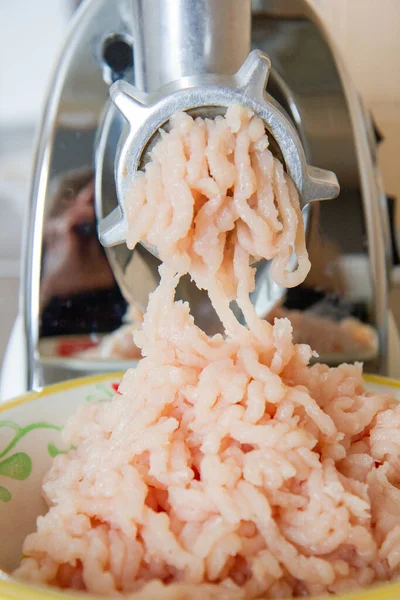 meat grinder grinds chicken meat into minced meat