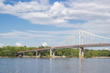 Kyiv 'deki Dinyeper Nehri' nin karşısındaki yaya köprüsünde insanlar nehrin kıyısında dinleniyor.