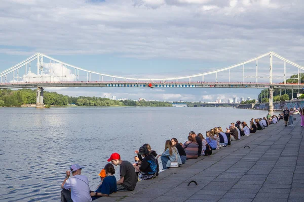 Kyiv 'deki Dinyeper Nehri' nin karşısındaki yaya köprüsünde insanlar nehrin kıyısında dinleniyor.