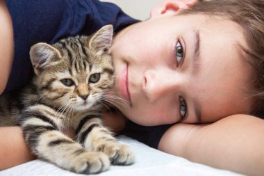 boy and cat on the bed