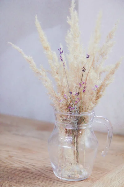 Bouquet of dried flowers in a transparent vase on the table