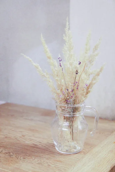 Bouquet of dried flowers in a transparent vase on the table