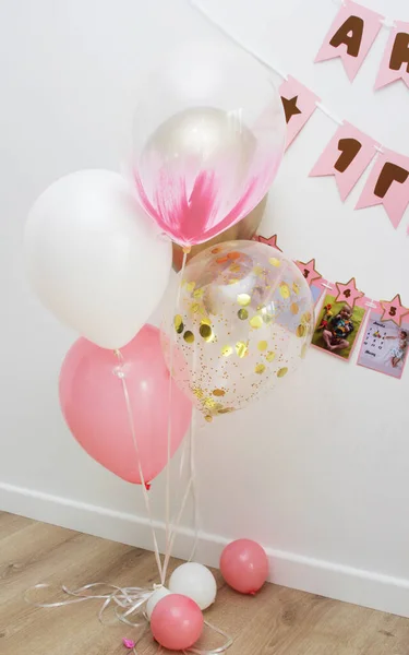 Pink photo zone with balloons, garlands and a number for 1 year