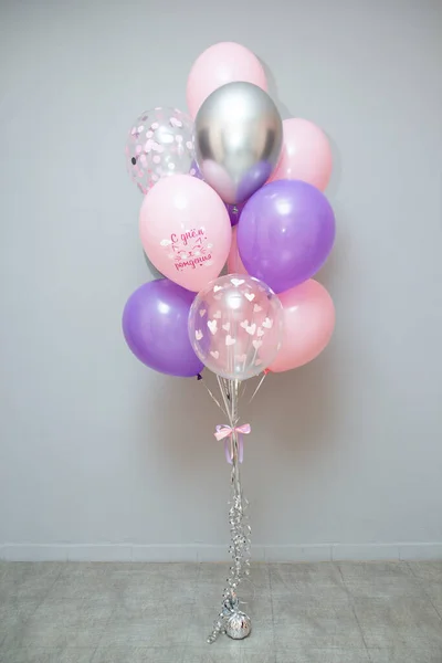 A set of pink and purple balloons for a party. The inscription on the balloon 