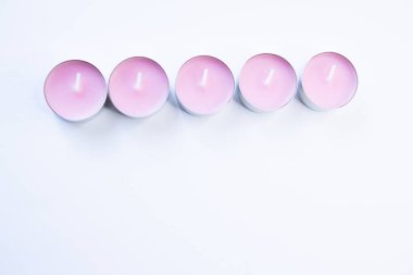 Beyaz arkaplanda pembe mumlar