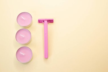 Sarı arka planda pembe jilet ve mumlar