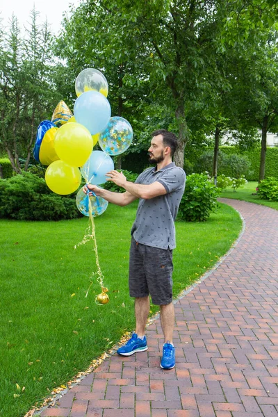 man in the park with balloons