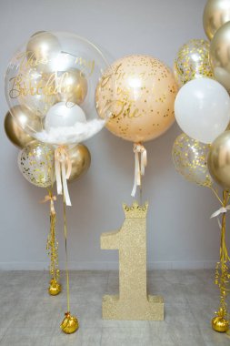 golden and white balloons with helium, holiday decoration with balloons, golden number one, first birthday