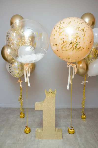 golden and white balloons with helium, holiday decoration with balloons, golden number one, first birthday