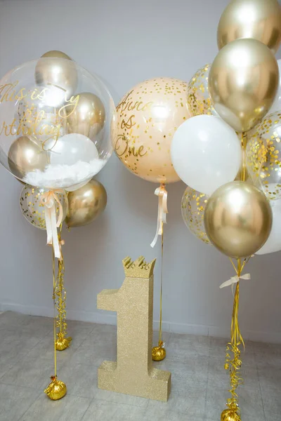 golden and white balloons with helium, holiday decoration with balloons, golden number one, first birthday