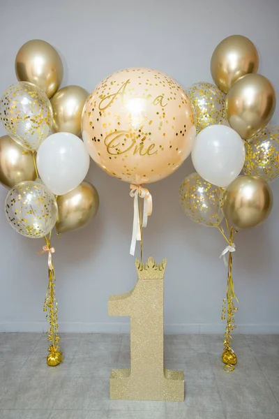 golden and white balloons with helium, holiday decoration with balloons, golden number one, first birthday