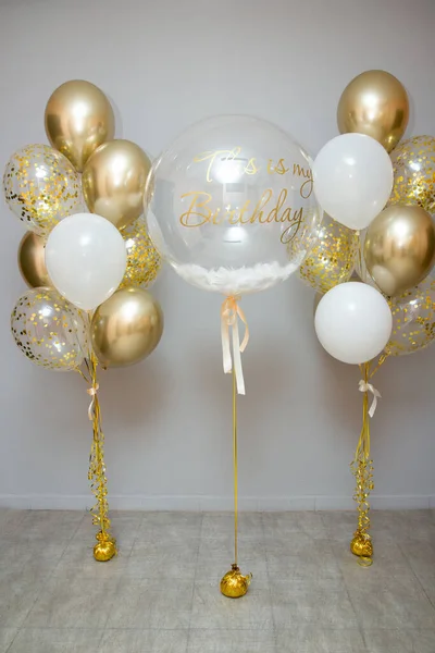 golden and white balloons with helium, decoration of the holiday with balloons, balloon photo zone