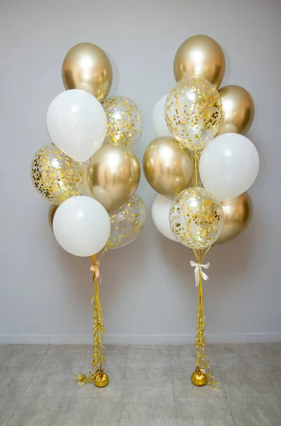 golden and white balloons with helium, decoration of the holiday with balloons, balloon photo zone