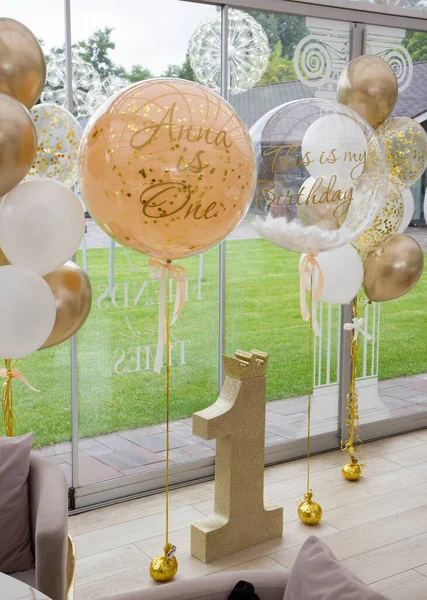 beige balloons with helium, decoration with balloons for one year, golden number one, photo zone for 1 year