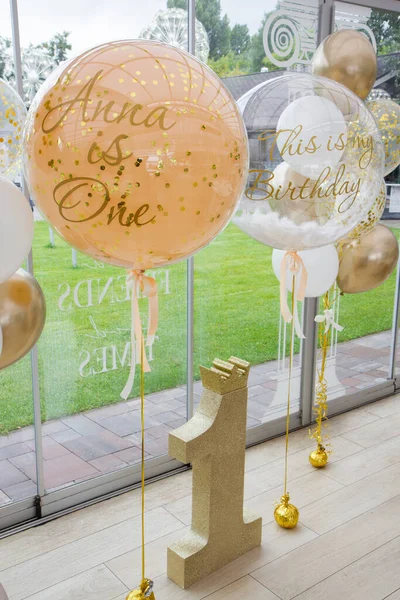 beige balloons with helium, decoration with balloons for one year, golden number one, photo zone for 1 year