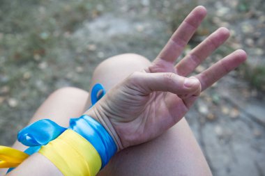 blue-yellow ribbons on the hands, the flag and the trident of Ukraine