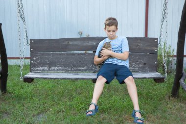a boy hugs a cat, a happy child holds a cat in his arms